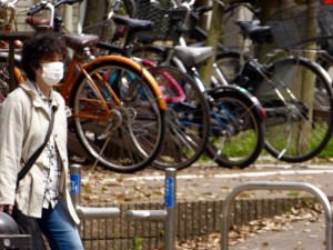 walker in Fukuoka, wearing mask; despite lots of bicycle use, pollution and pollen result in lots of masks. 