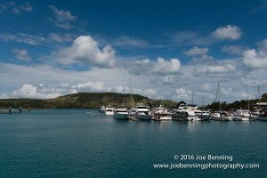 Ships anchored at the Hamilton Island Yacht Club. Jet skiers glide by in the distance.