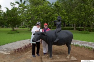 Mary Anne and Ricki pose by a statue of the Buddha on a cow, near Borobudur Temple.
