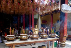 A Buddhist temple in Chinatown; you can see joss sticks in the front, and spiral incense coils hanging from the ceiling, with purple and red papers containing the petitions requesting prayers.  We saw many tourists but also many locals worshipping at the temple.  Because so many people came to Vietnam by boat, this temple is dedicated to the gods and goddesses of water travel.  There is also a shrine to the god of business (who rewards his worshippers with prosperity).  The temple is open air, and you can see a plastic cover over the fan in the  upper right corner.