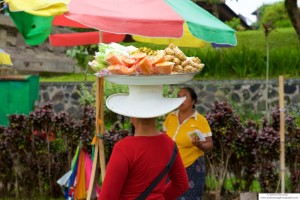 Woman balancing fruits and vegetables on her head in the market in Bali, Indonesia.