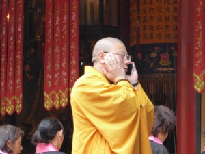 a monk at the service takes a quick call