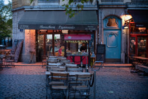 Traditional French bouchon restaurant storefront lit up at dusk in Lyon, France