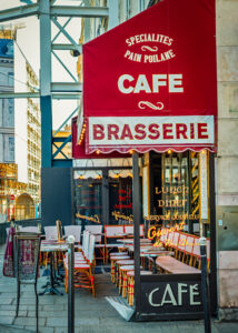 Red-and-white awning of a traditional Paris cafe and brasserie with outdoor bistro seating