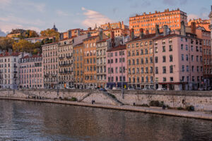 Colorful riverside buildings along the Sa&ocirc;ne River in Lyon, France at sunset