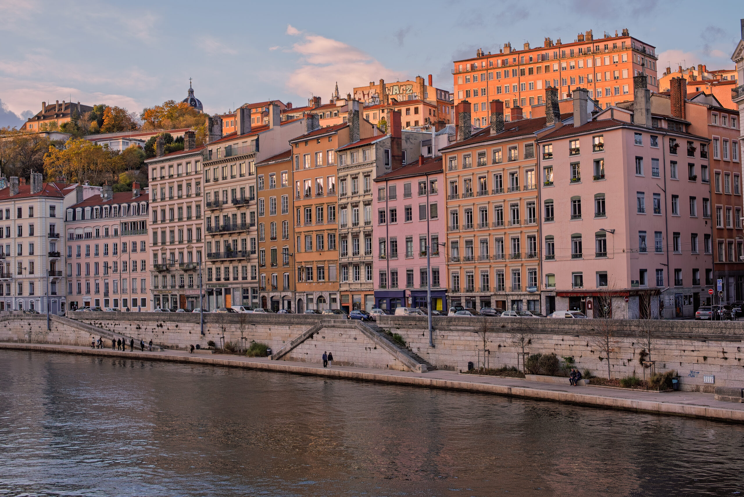 Colorful riverside buildings along the Sa&ocirc;ne River in Lyon, France at sunset
