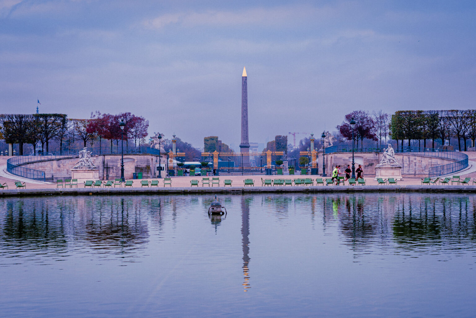 Golden-tipped Luxor Obelisk reflected in a still pond at Place de la Concorde, Paris