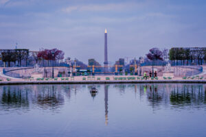 Golden-tipped Luxor Obelisk reflected in a still pond at Place de la Concorde, Paris