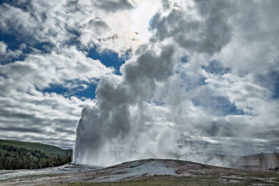 Old Faithful Erupts Beneath Dramatic Clouds