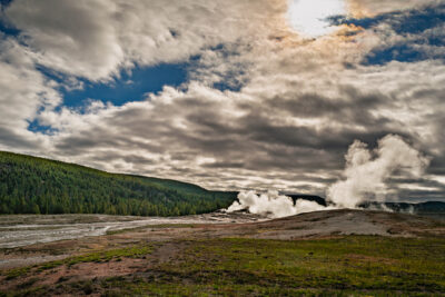 Old Faithful Full Eruption with Dramatic Plume Against Stormy Clouds