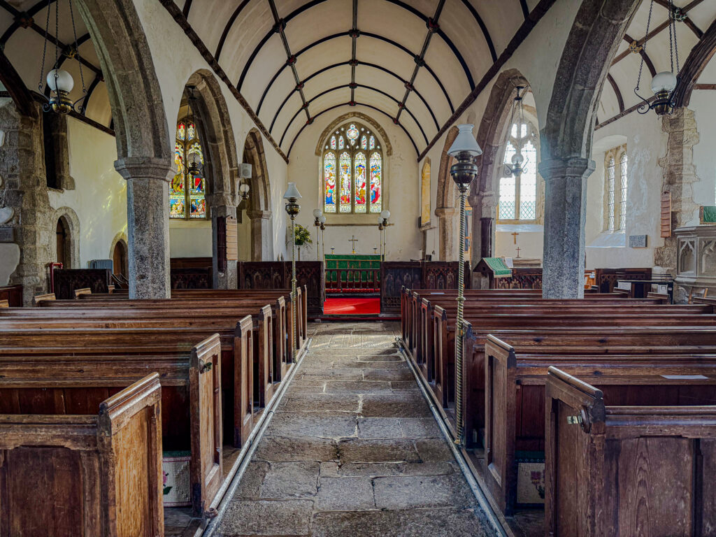 Stone arches and wooden pews inside St Pancras Church in Widecombe-in-the-Moor, Dartmoor, Devon.