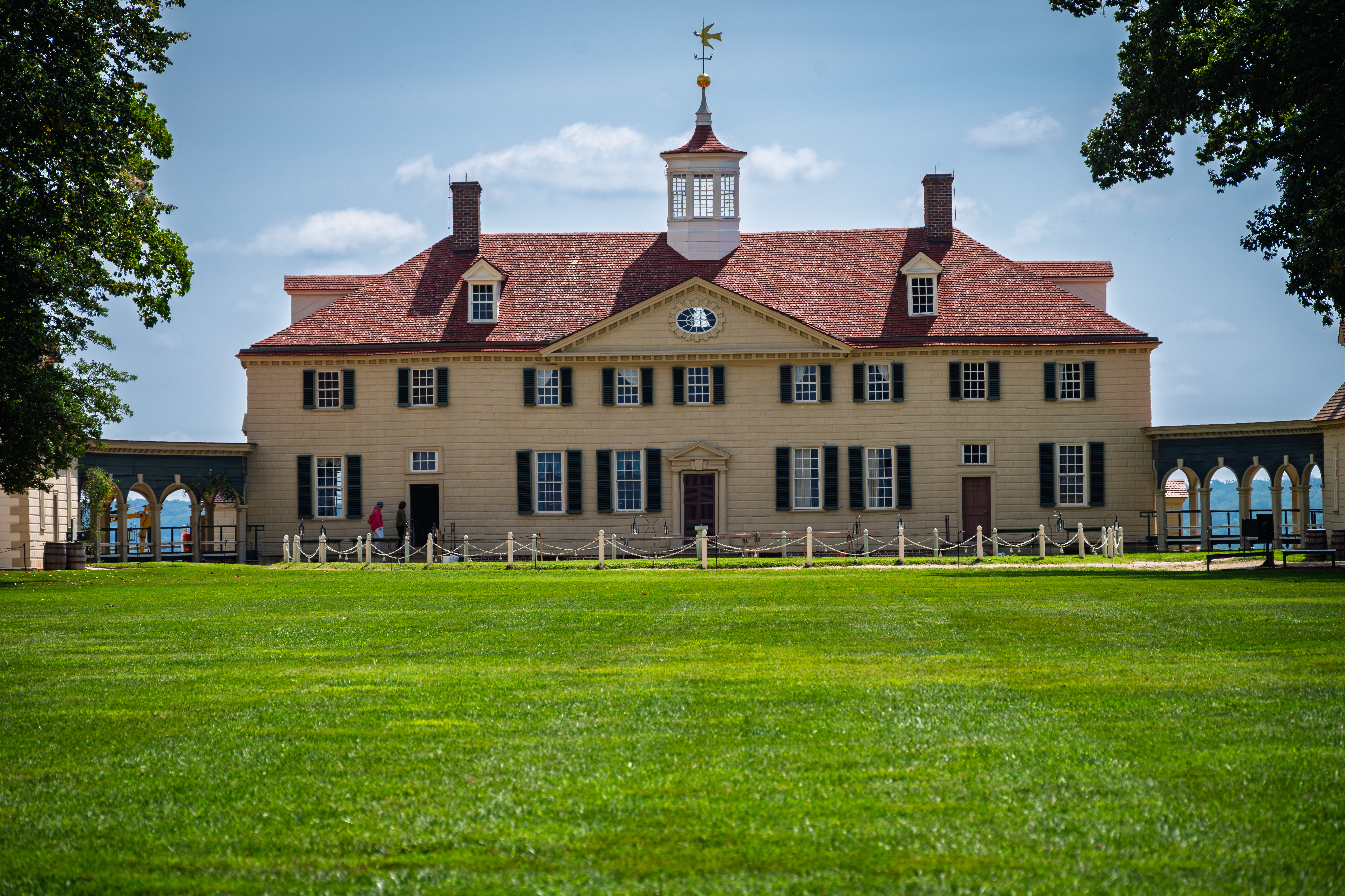 Front view of George Washington's Mount Vernon mansion with green lawn in Virginia