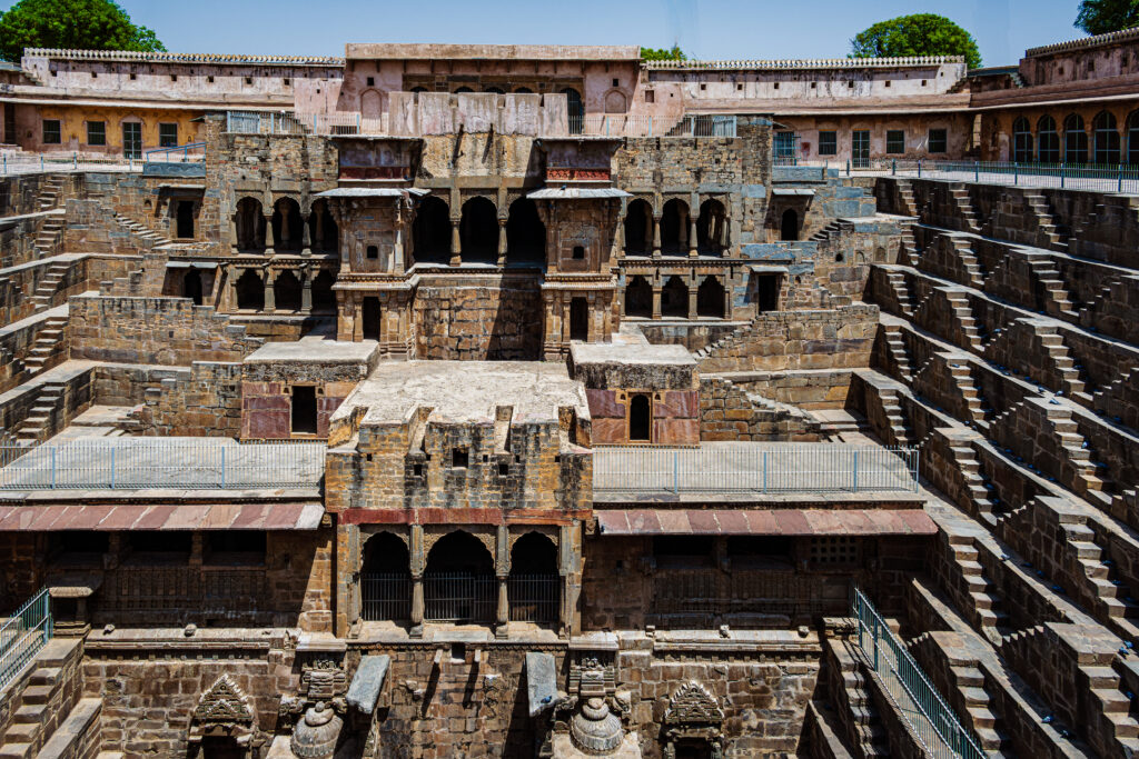 A tiered pavilion rises above the deep geometric stairways of Chand Baori.