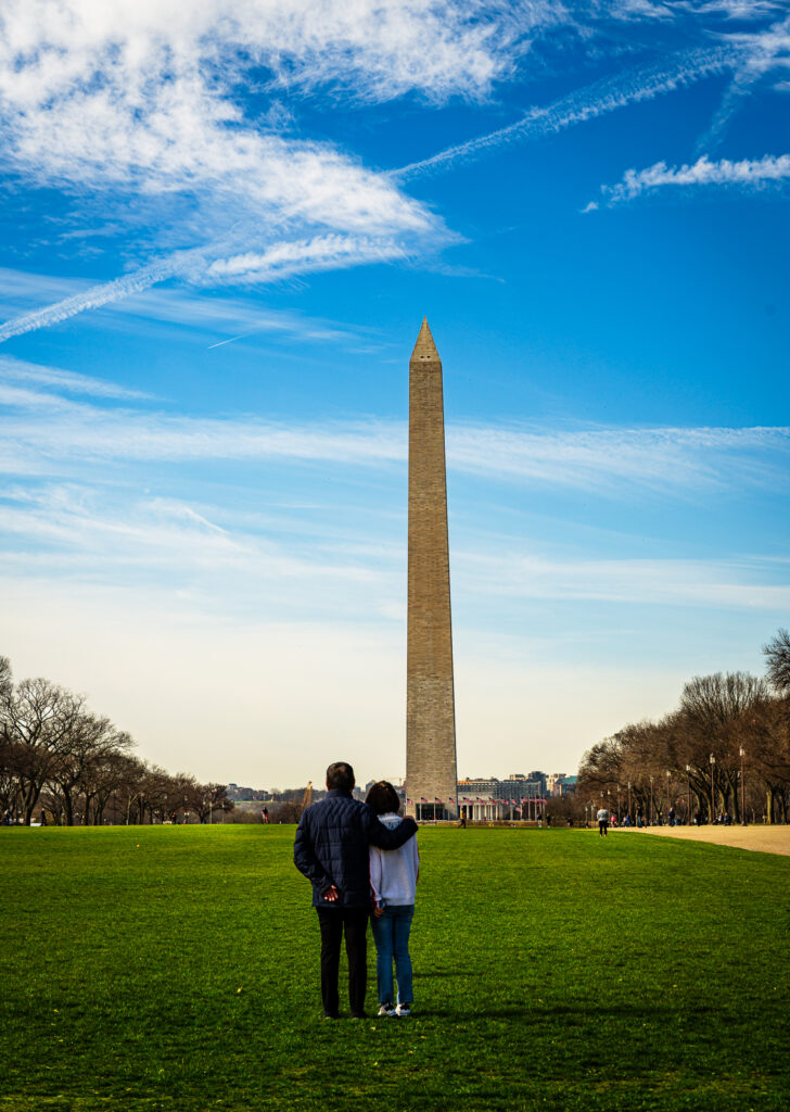 Couple on the National Mall gazes at the Washington Monument.