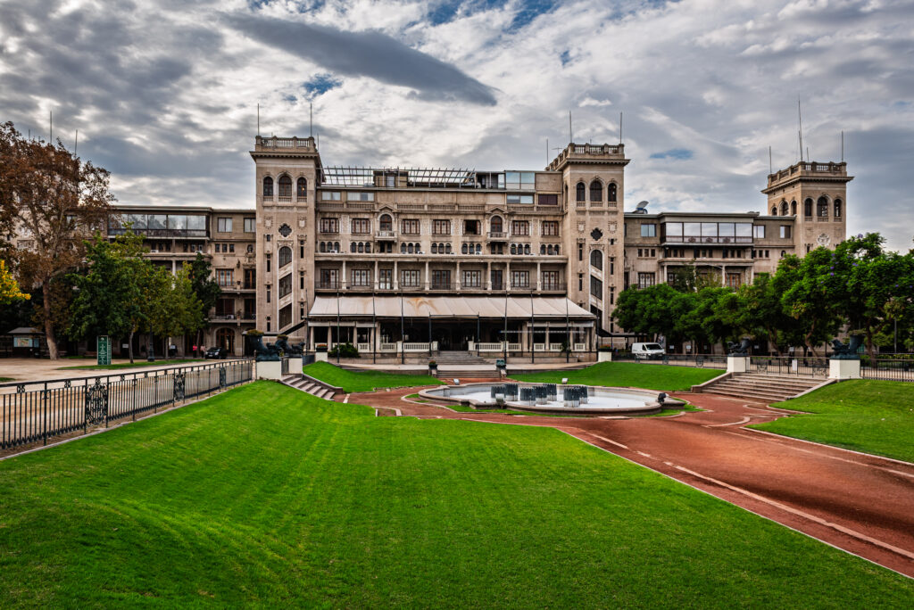 Historic grandstand above green lawns and a curved race track in Santiago, Chile.