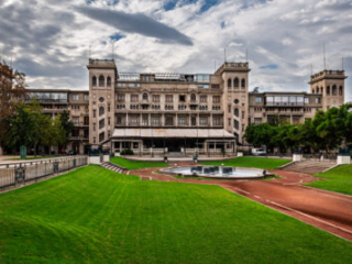 Historic grandstand above green lawns and a curved race track in Santiago, Chile.