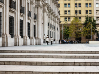 Police officers beside La Moneda palace in Santiago, viewed across broad stone steps.