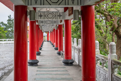 Rows of red columns frame a covered temple walkway in Taiwan.