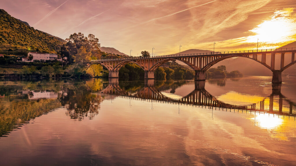 Golden sunset over the Ponte Rodovi&aacute;ria da R&eacute;gua reflected in the Douro River at Peso da R&eacute;gua, Portugal.